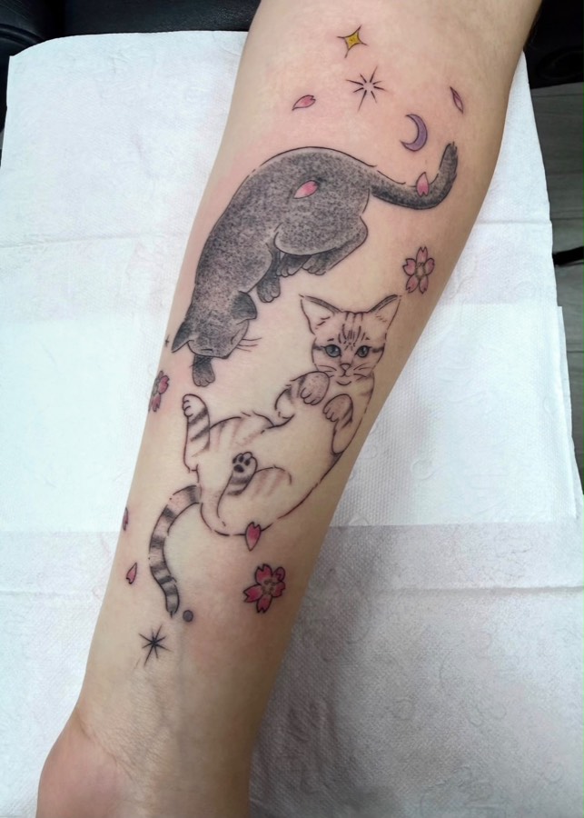 Tatuaje de dos gatitos entre flores de sakura